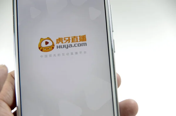 中国の携帯電話ユーザーは 中国東部山東省の江南市のスマートフォンで中国のライブストリーミング会社YyのゲームビデオストリーミングプラットフォームHuyaのアプリを使用しています 2016年8月27日 — ストック写真
