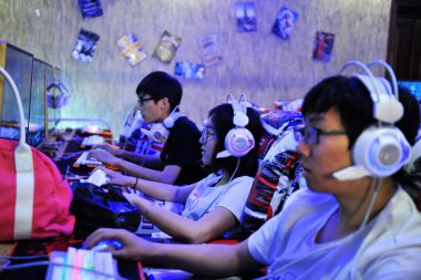 Young Chinese netizens play online games at an Internet cafe in Qingdao city, east China's Shandong province, 1 June 2016.  clipart