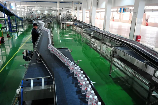 中国の労働者は 2017 日中国中央部の湖北省宜昌市の工場での組立ラインで Wahaha 精製水のボトルをチェックします — ストック写真