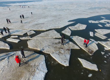 Tourists enjoy themselves on the floating melted sea ice at the Bohai Sea or Bo Sea, also known as Bohai Gulf, Bo Gulf or Pohai Bay in Dalian city, northeast China's Liaoning province, 21 February 2018. clipart