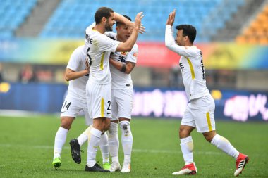 Spanish soccer player Mario Suarez, left, of Guizhou Hengfeng, celebrates with his teammates after scoring a goal against Hebei China Fortune in their second round match during the 2018 Chinese Football Association Super League (CSL) in Guiyang city,