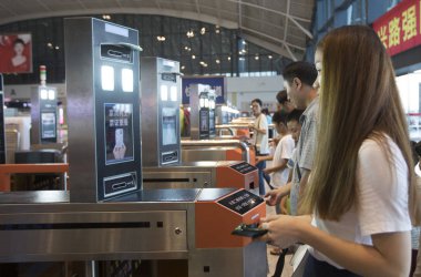 Chinese passengers have their faces scanned by a face recognition system to check in at a railway station in Wuhan city, central China's Hubei province, 22 August 2017 clipart