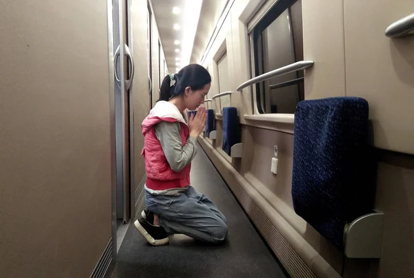 Danliu 重度の脳腫瘍と水頭症と診断された 5歳の中国の少年ハオハオの母 ひざまずいは 北京から上海への電車の中で彼女の息子のために祈るためにダウンして 4月9日2018 — ストック写真