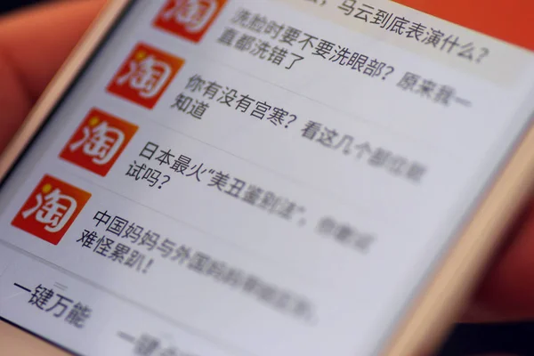 オンライン ショッピング サイト Taobao Com 2017 日中国東部の山東省済南市でのショッピングのための彼のスマート フォンの中国電子商取引大手アリババ グループの中国の携帯電話ユーザー参照 — ストック写真