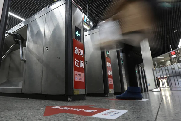 A passenger puts her smartphone above a turnstile to have the QR code on a mobile app scanned to pay for subway ticket via Alipay or China UnionPay and enter the metro station at the Longyang Road Station in Shanghai, China, 16 January 2018