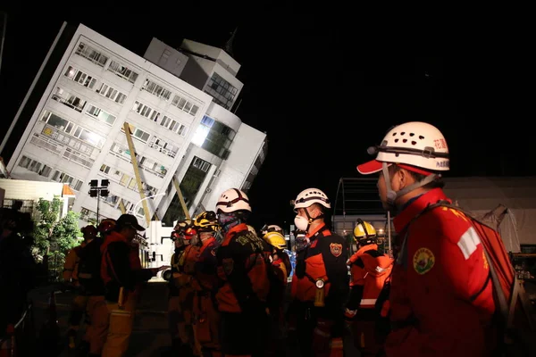 Διασώστες Στέκονται Μπροστά Από Ένα Μερικώς Συμπτυγμένο Κτήριο Κατοικιών Που — Φωτογραφία Αρχείου