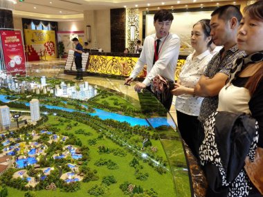 Chinese homebuyers look at housing models at the sales center of a residential property project in Ma'anshan city, east China's Anhui province, 10 September 2017.    clipart