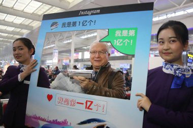 79-year-old American businessman Charles Bingham, who is the city's 100 millionth outbound train passenger this year, poses for photos after he bought train tickets at the Hongqiao Railway Station in Shanghai, China, 4 December 2017 clipart