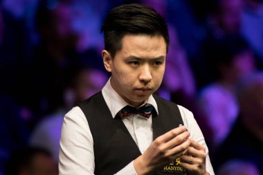 Xiao Guodong of China chalks his cue as he considers a shot to Martin Gould of England in their fourth round match during the 2017 Betway UK Championship snooker tournament in York, UK, 7 December 2017