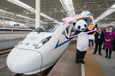 A performer dressed as giant panda welcomes passengers beside a CRH (China Railway High-speed) bullet train on the Xi'an-Chengdu (Xicheng) High-Speed Railway before it leaves Chengdu East Railway Station for Xi'an North Railway Station in Chengdu, so clipart