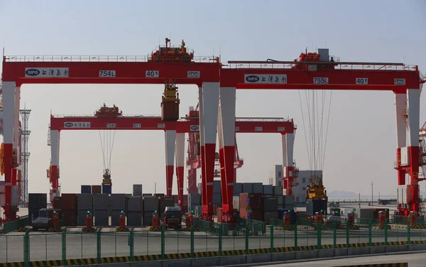 Crane vehicles lift containers at the fourth phase of the Yangshan Deep-Water Port, the world's largest automated cargo wharf to start trial operation, in Shanghai, China, 6 December 2017 — Stock Image Crane Vehicles Lift Containers Fourth Phase Yangshan Deep Water Port Royalty Free Stock Photos