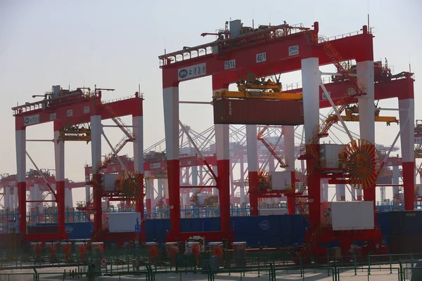 Crane vehicles lift containers at the fourth phase of the Yangshan Deep-Water Port, the world's largest automated cargo wharf to start trial operation, in Shanghai, China, 6 December 2017 — Stock Image Crane Vehicles Lift Containers Fourth Phase Yangshan Deep Water Port Stock Picture