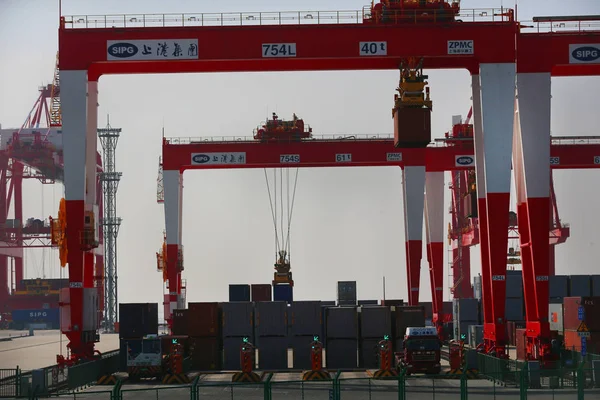 Crane vehicles lift containers at the fourth phase of the Yangshan Deep-Water Port, the world's largest automated cargo wharf to start trial operation, in Shanghai, China, 6 December 2017 — Stock Image Crane Vehicles Lift Containers Fourth Phase Yangshan Deep Water Port Royalty Free Stock Images