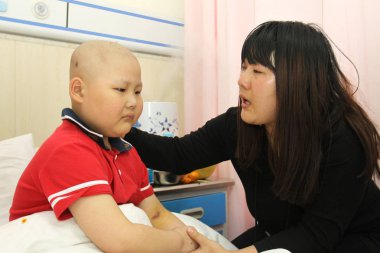 28-year-old Chinese woman Meng Xianglan diagnosed with aplastic anemia takes care of her 6-year-old son Jiao Zhenheng diagnosed with leukemia, also spelled leukaemia, at a hospital in Harbin city, northeast China's Heilongjiang province, 6 December 2 clipart