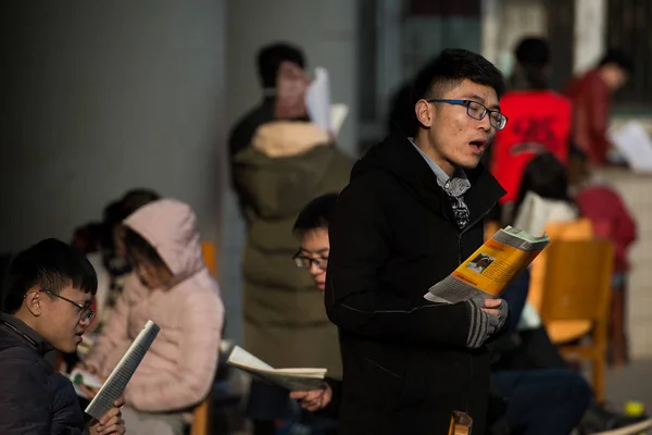 中国の学部生は 2017年12月17日 中国中部武漢市の大学で図書館の外に立ち 2018年の全国大学院入試の本を読みます — ストック写真