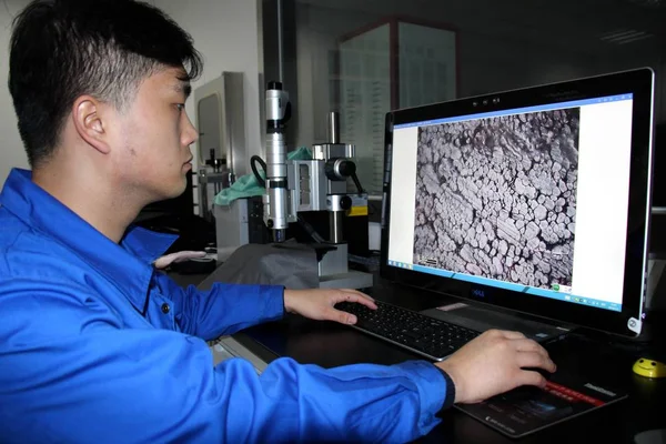 中国東部山東省ビンゾウ市の繊維会社でカーボンナノ材料をベースに開発された中国初の遠赤外線伝導加熱繊維の構造を 走査型電子顕微鏡で観察するチーネスの労働者が1月3日に — ストック写真