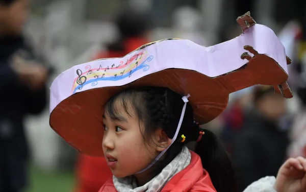 若い中国人の女の子学生は 2019 日南校 Tiantaigang 小学校の帽子ショーの間に彼女の作成を表示します — ストック写真