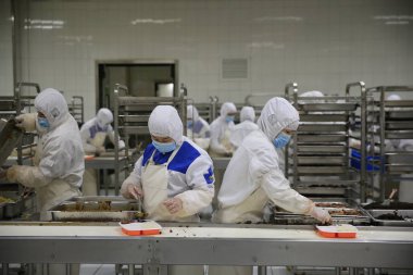 Chinese workers fill lunch boxes with food on the production line at a food processing plant of Beijing Jingtie Train Service Co., Ltd. in Beijing, China, 19 January 2017 clipart