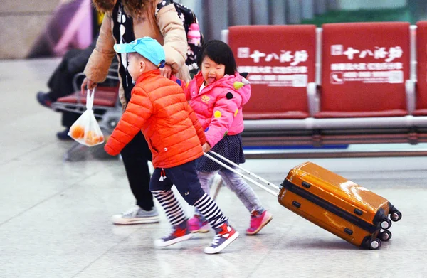 若い中国の子供たちは 荷物を運ぶ彼らはまた 春祭りとして知られている今後の中国の旧正月のために母親と一緒に家に帰るとして石家荘駅で実行されます 石家荘市 北中国の河北省 — ストック写真