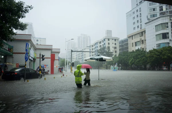 Офицер Китайской Полиции Помогает Местному Жителю Пройти Затопленной Дороге Вызванной — стоковое фото
