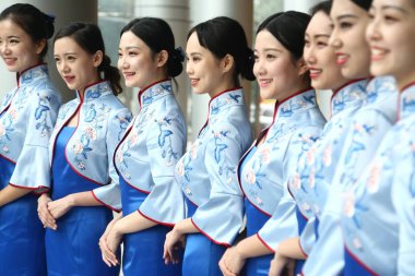 Chinese volunteers wearing cheongsam (qipao) pose during a ceremony for the upcoming fourth World Internet Conference (WIC), also known as Wuzhen Summit, in Wuzhen town, Tongxiang city, Jiaxing city, east China's Zhejiang province, 27 November 2017 clipart