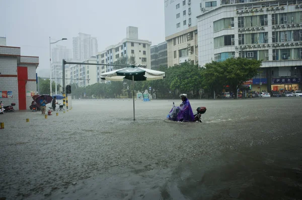 2017年11月14日 在中国海南省海口市 一名骑自行车的人在大雨造成的道路被淹时开车 — 图库照片