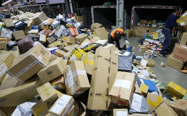 2017年11月12日 中国工人在中国东部山东省潍坊市一家快递公司的配送中心 对成堆的包裹进行分类 其中大部分来自光棍日网购 — 图库照片
