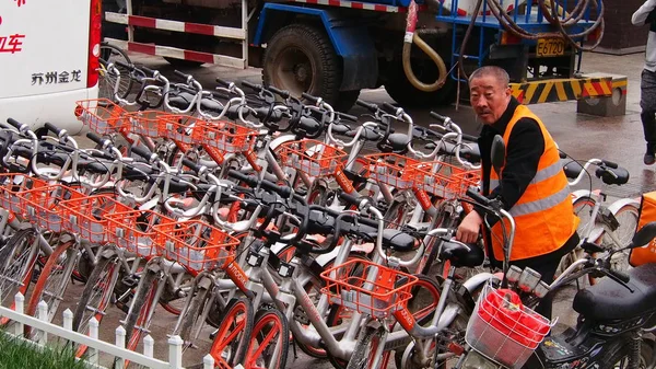 中国の従業員は 中国東部の山東省 Nan市の道路に自転車シェアリングサービスMobikeの自転車を表示します 2017 — ストック写真
