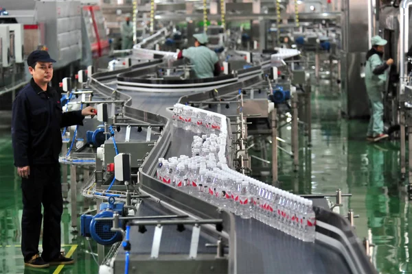 中国の労働者は 中国中部の湖北省のYichang市の工場で 組み立てライン上のワハハ浄化水のボトルをチェックします 2017年2月15日 — ストック写真