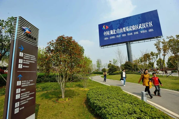 歩行者は 中国中部の湖北省武漢市の中国 パイロット自由貿易区武漢地域の標識を通り過ぎる 2017年4月1日 — ストック写真