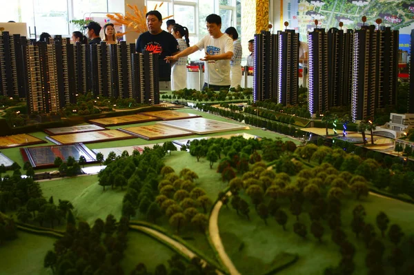 中国购房者在中国中部湖北省宜昌市一个住宅物业项目的销售中心查看住房模型 — 图库照片