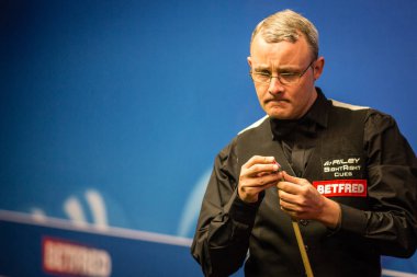 Martin Gould of England chalks his cue as he considers a shot to John Higgins of Scotland in the first phase of their first round match during the 2017 Betfred World Snooker Championship at the Crucible Theatre in Sheffield, UK, 17 April 2017