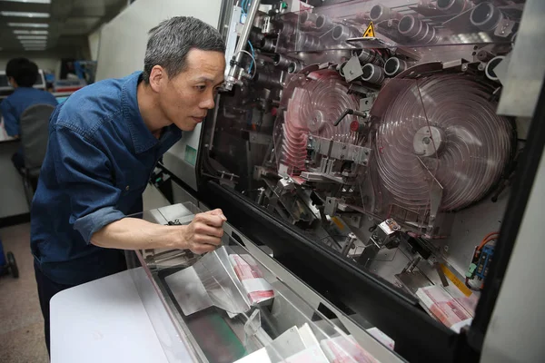 中国人労働者のチェ ジャングアンは 中国北部の河北省四家荘市にある中国紙幣印刷と造幣公社 Cbpmc の工場で人民元 人民元 紙幣を製造するために使用される機器をチェックします — ストック写真