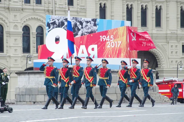 第154プレオブラジェンスキー独立司令部の兵士は ナチスGに対する勝利の72周年を記念して 勝利の日の軍事パレード中に赤の広場に沿って行進するロシアの国旗と勝利の旗を運びます — ストック写真