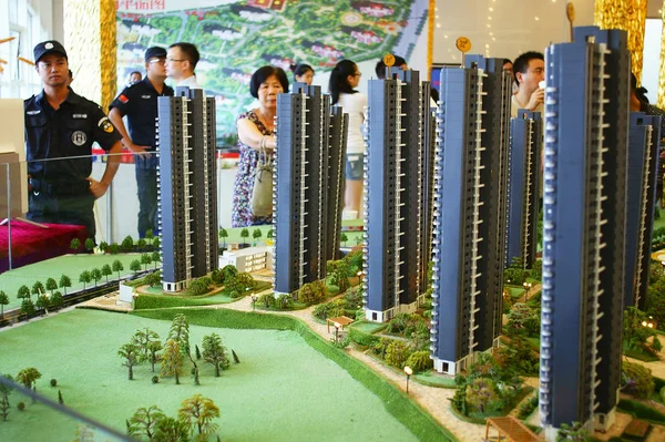 中国购房者在中国中部湖北省宜昌市一个住宅物业项目的销售中心查看住房模型 — 图库照片