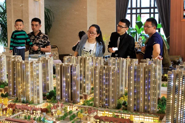 中国购房者在中国东部山东省日照市一个住宅物业项目的销售中心查看住房模型 — 图库照片