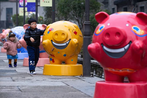 2019年1月6日 中国江苏省南京市东中化门历史文化区 年幼的中国孩子们在玩猪形雕塑 — 图库照片