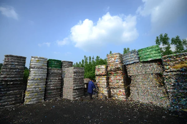 Een Chinese Arbeider Arbeid Voorkant Van Hoge Palen Van Plastic — Stockfoto