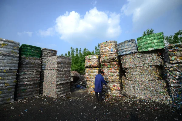 Een Chinese Arbeider Arbeid Voorkant Van Hoge Palen Van Plastic — Stockfoto