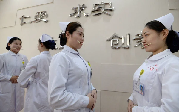 Kvinnliga Sjuksköterskor Bita Ätpinnar Att Öva Leende För Patienter Att — Stockfoto
