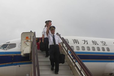 Flight crew members deplane after the last Boeing 737-300 passenger jet of China Southern Airlines landed during its last flight at the Zhengzhou Xinzheng International Airport in Zhengzhou city, central China's Henan province, 8 May 2017 clipart
