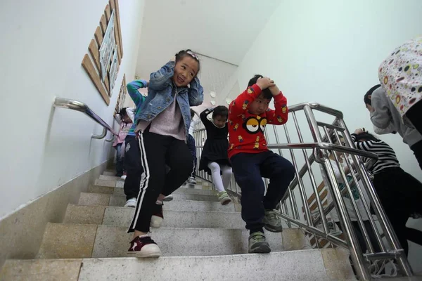 Young Chinese Kids Shielding Heads Hands Rush Downstairs Earthquake Preparedness — Stockfoto