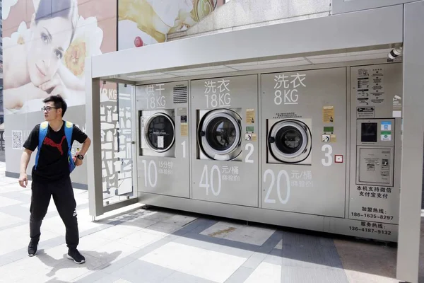 2017년 19일 상하이 시내의 쇼핑몰 외부에 설치된 세탁기를 지나가는 보행자 — 스톡 사진