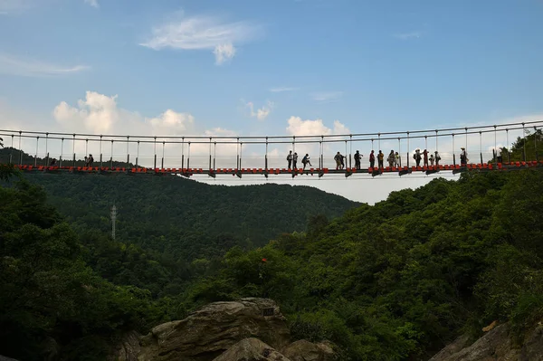Туристы Прогуливаются Подвесному Стеклянному Мосту Через Горы Живописном Месте Мулан — стоковое фото
