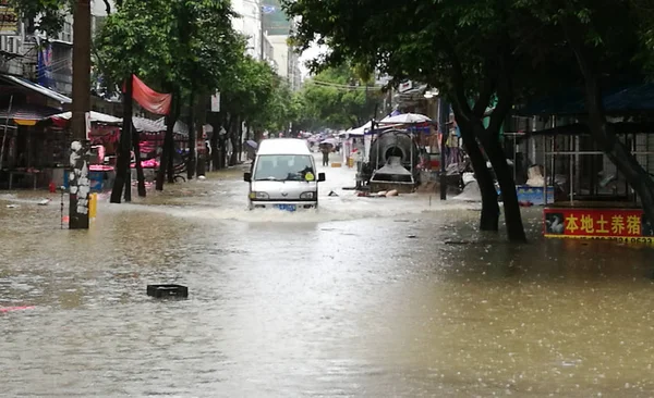 Ένα Αυτοκίνητο Ταξιδεύει Μέσα Από Ένα Πλημμυρισμένο Δρόμο Που Προκαλείται — Φωτογραφία Αρχείου