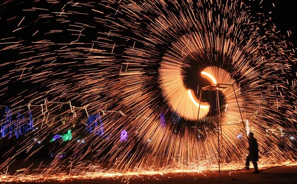 2017年2月11日 在中国中部河南省安阳市内黄县举行的元宵节庆祝活动中 一名表演者转动车轮旋转铁水 制造火花 — 图库照片