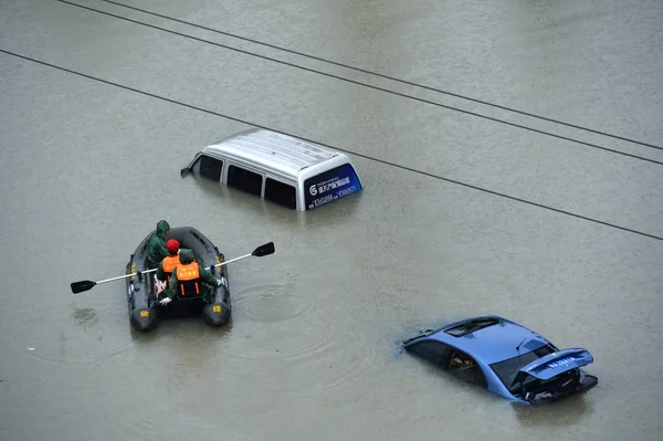 Εργαζόμενοι Προσπαθούν Εκκενώσουν Ένα Αυτοκίνητο Σχεδόν Βυθισμένο Πλημμυρισμένο Δρόμο Που — Φωτογραφία Αρχείου