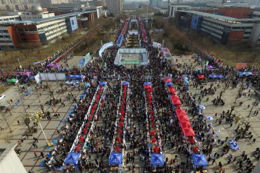 Aerial view of graduates crowding booths to seek for employments during a job fair at a college campus in Shijiazhuang city, north China's Hebei province, 8 February 2017 clipart