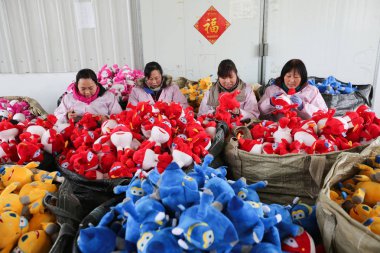 Female Chinese workers sew stuffed toys to be exported at a toy factory in Lianyungang city, east China's Jiangsu province, 3 February 2017 clipart