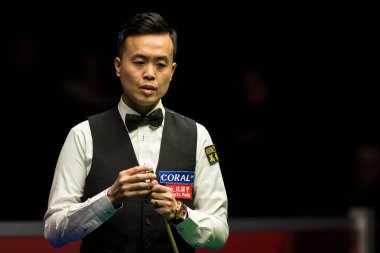 Marco Fu of Hong Kong chalks his cue as he considers a shot to Martin Gould of England in their first round match during the Welsh Open 2017 snooker tournament in Cardiff, Wales, UK, 14 February 2017
